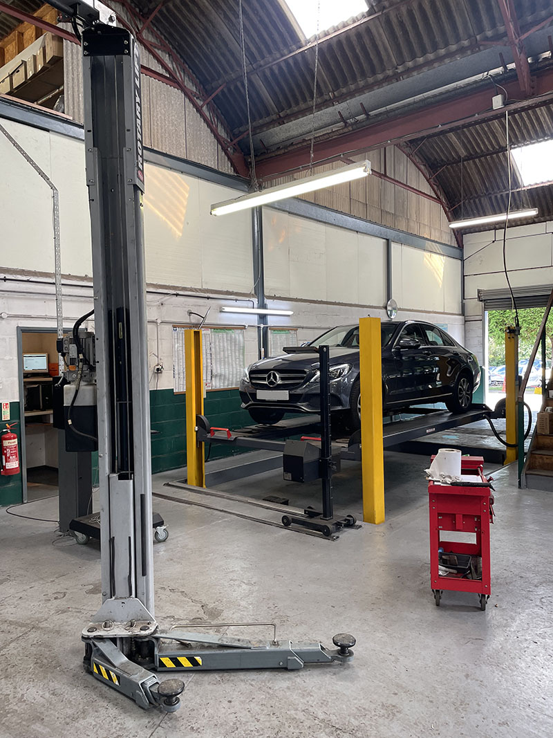 mercedes e-class lifted up on car lift in garage for servicing
