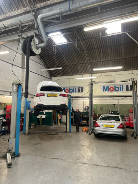 Mercedes vehicles being serviced on lifts