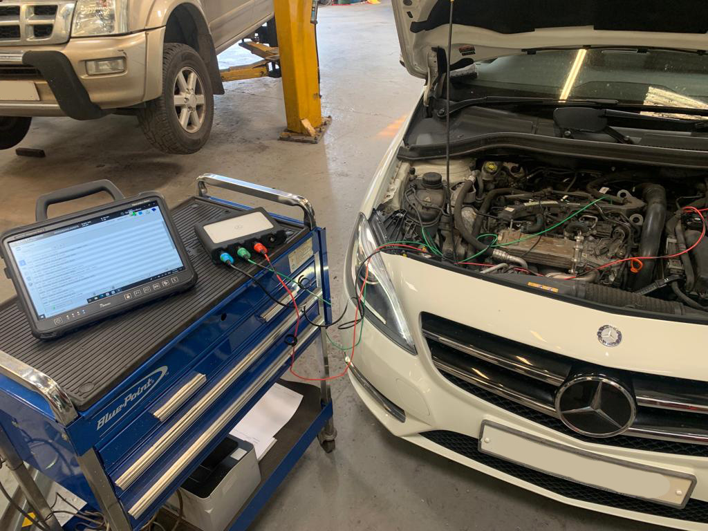 Mercedes Benz Star Diagnostics equipment attached to white mercedes SUV
