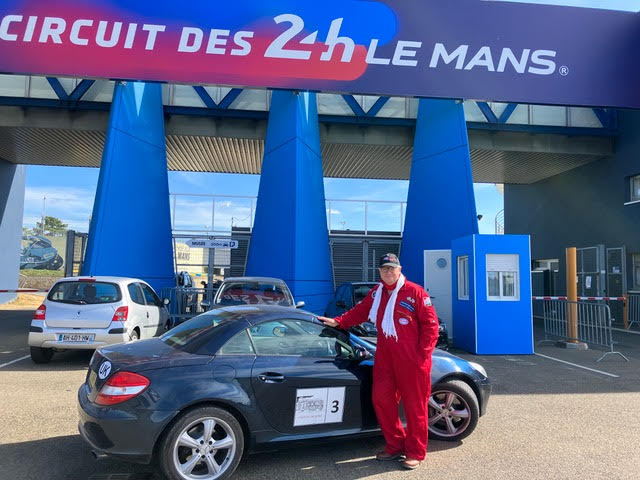 Customer who took part in a classic car rally standing next to his Mercedes